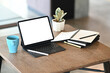 © Prathankarnpap - Simple workspace with isolated white display computer tablet, coffee cup, plant and notebooks on wooden table.