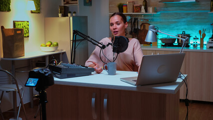 Wall Mural - Person speaking about her life during podcast in home studio with neon light behind her. Creative online show On-air production internet broadcast host streaming live content, recording digital social