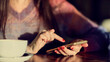 © yavdat - unrecognizable Young woman using smartphone with a coffee cup. Toned picture.