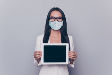 Sticker - Photo portrait of woman in blue face mask showing tablet with blank space isolated on white colored background