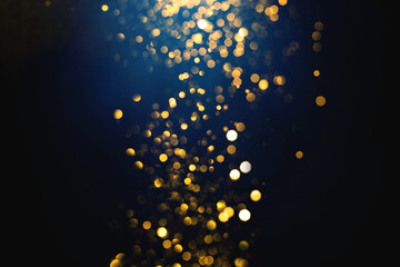 Wall Mural - golden abstract bokeh on dark blue background. holiday concept