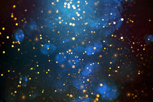 Golden Abstract Bokeh On Dark Blue Background. Holiday Concept