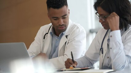 Wall Mural - Young doctors working on laptop at the hospital