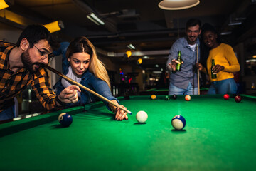 Wall Mural - Group of friends having fun in bar playing billiard together.