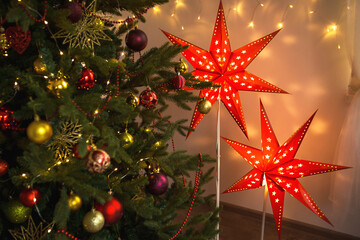 red christmas star-lamp on a stand. the festive decor of the interior of the house. christmas, new y