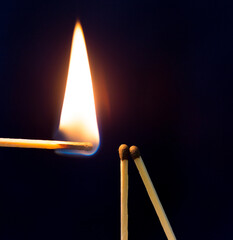 two matchstick lit on black background