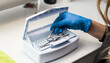 © Krievietka - Woman in blue gloves sterilizes manicure tools in the nail tool sterilizer machine. Safe concept. Safe manicure and pedicure. Image for beauty salon and sites about manicure. Beauty sphere.