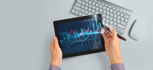 Wall Mural - Hand holding tablet and showing holographic graphs stock market statistics gain profits