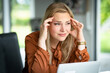 © Countrypixel - Stress am digitalen Arbeitsplatz, junge Frau mit Kopfschmerzen bei der Arbeit in der Büro.