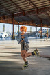 © Cavan Images - Young alternative redhead dancing in roller skates inside a hangar
