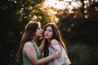 © Cavan Images - Young woman is about to kiss her girlfriend in forest during summer