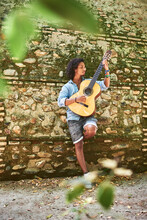 Young Man With Brown Skin With A Classical Spanish Guitar.
