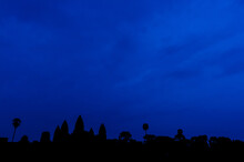 Angkor Park. Siem Reap, Cambodia. Silhouette Of  Five Angkor Wat Towers Against Dawn Blue Sky.