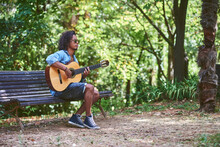 Musician Playing Guitar In A Nice Park.