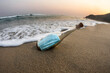 © Cavan Images - Surgical face mask inside a glass bottle at the beach