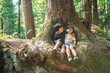 © Cavan Images - Two young boy friends embrace happily under large tree