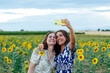 © Cavan Images - mother and daughter hugging taking a picture with the smartphone