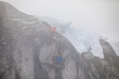 © Cavan Images - Climbers rappelling onto portaledge as stormy weather blows in.