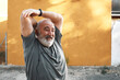 © Cavan Images - An old man is stretching out his arm with a sore face