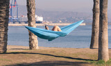 Fototapeta Uliczki - Malaga, Spain - November 01, 2020.Woman in a hammock on the beach.