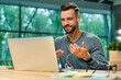 © InsideCreativeHouse - Attractive 30s caucasian businessman having online conversation using laptop and headphones at office desk