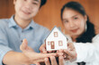 © Cavan Images - Young couple showing house model.