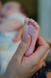 © Cavan Images - mother stroking her baby's foot