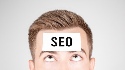Poster - Man looking at paper with word SEO pasted on his forehead