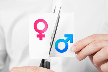 Poster - man cuts scissors sticker with man and woman sign on it