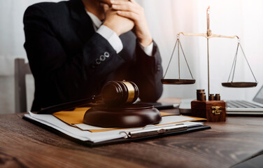 Justice and law concept.Male judge in a courtroom with the gavel, working with, computer and docking keyboard, eyeglasses, on table in morning light