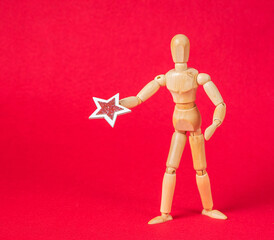 Business and design concept - wooden mannequin with stars on a red background