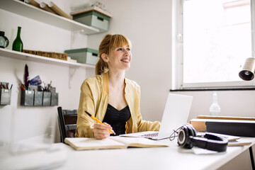 Happy woman working from home looking up