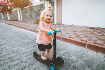 Baby girl riding scooter in city happy child 1 year old healthy lifestyle family fun activity outdoor