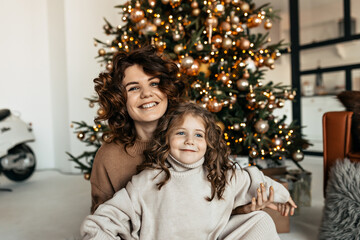 Wall Mural - Portrait of happy family in knitted clothes celebrating Christmas and New Year