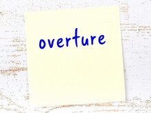 Yellow Sticky Note On Wooden Wall With Handwritten Word Overture