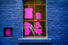 Abstract Of Pink Painted Window In Blue Brick Wall