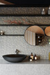 Modern bathroom interior with gray ceramic tiles and black washbasin. 3d render