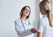 © SHOTPRIME STUDIO - woman doctor shakes hands with patient in white t-shirt