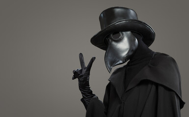 Wall Mural - The plague doctor shows a positive gesture on a gray background.