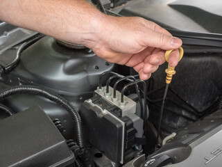 Canvas Print - Person measuring the oil level of a car