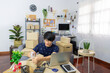 © Pichsakul - Asian man business owner or selling merchance online and prepare product packaging cardboard parcel box for send order shipment to client at home, shopping online, business owner, delivery concept.