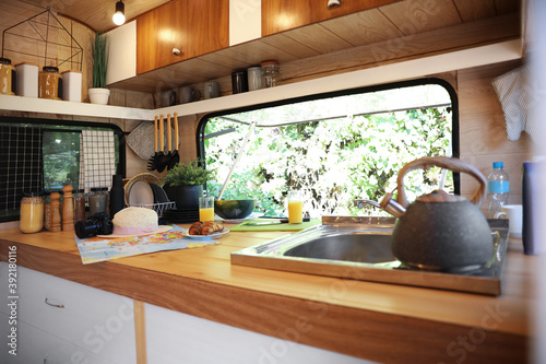 Stylish kitchen interior with different accessories and utensils in modern trailer. Camping vacation