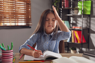 Canvas Print - Tired preteen girl at table. Doing homework