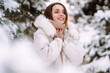 © maxbelchenko - Portrait of young beautiful woman  in a snowy park. Cheerful lady in winter clothes posing with joy outside in the snow forest. Winter holiday, Christmas, New year.