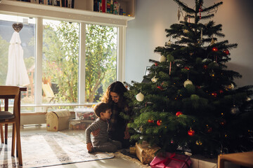 Sticker - Mother and son sitting by Christmas tree