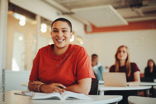 Obraz na płótnie Portrait of a smiling girl sitting in university classroom