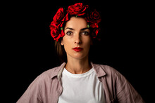 Beautiful Young Woman In A Wreath Of Red Flowers On A Black Background.