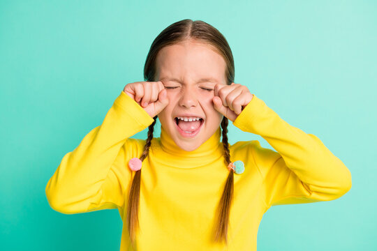 Photo of unhappy sad brown haired little girl cry stressed offended isolated on shine teal color background