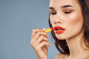 Woman with lipstick on a gray background brunette makeup with eye shadow on the eyelids