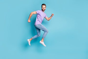 Wall Mural - Full length body size side profile photo of young bearded student jumping high running isolated on vibrant blue color background